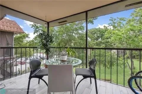 a view of a balcony with chairs and wooden floor