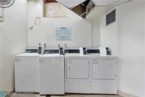 a view of a swimming pool with a yard and large trees