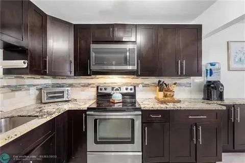 a kitchen with granite countertop stainless steel appliances and cabinets