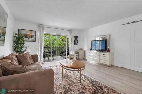 a living room with furniture a flat screen tv and a large window