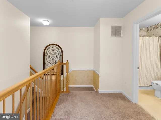 a view of staircase with railing and white walls