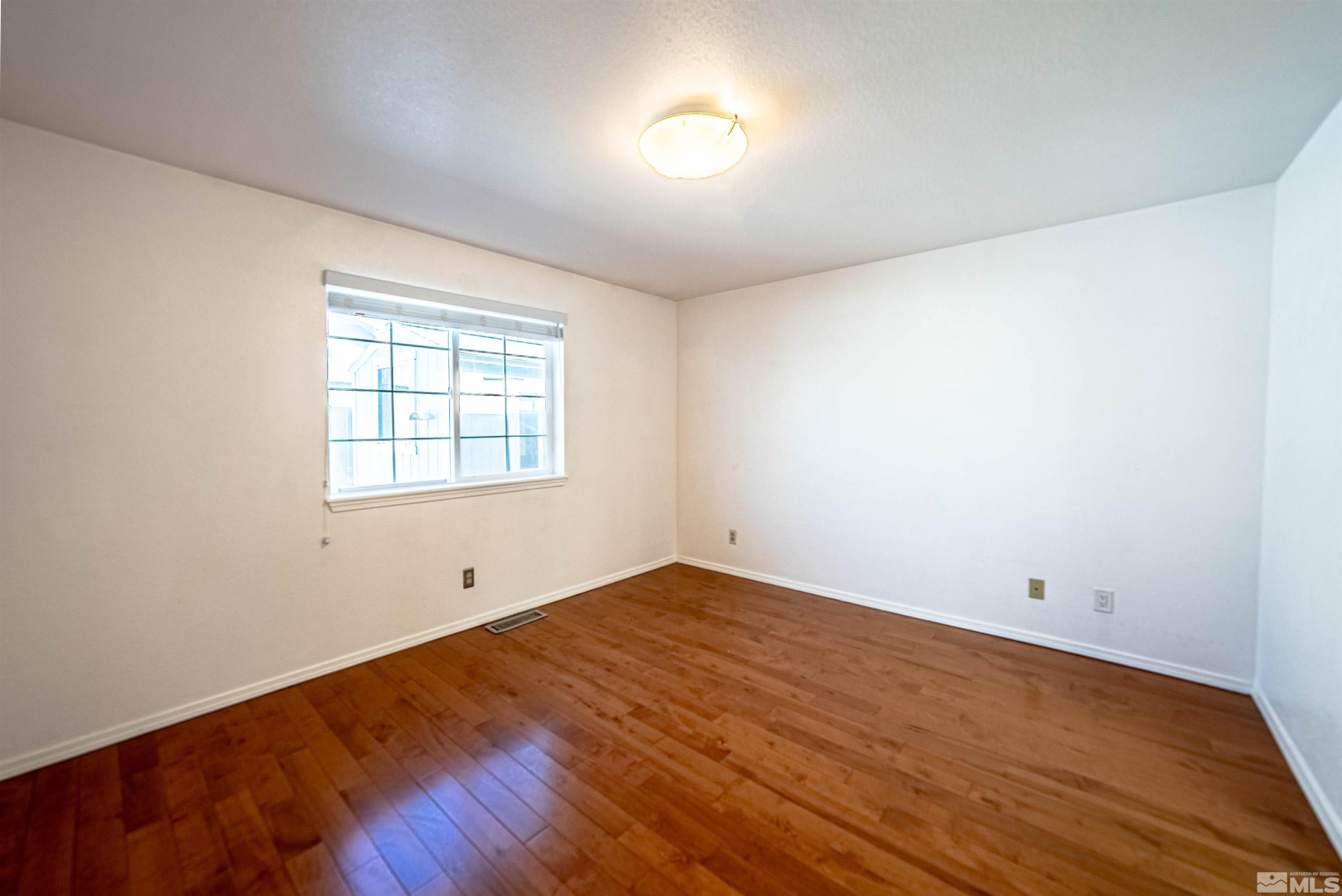 980 Ridgeview Drive Carson City, NV 89705 - Photo 11 of 18 an empty room with wooden floor and windows