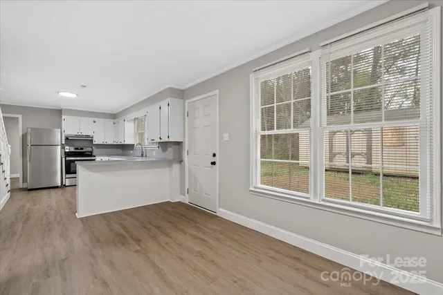 a kitchen with a refrigerator and white cabinets