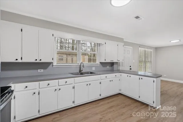 a kitchen with granite countertop white cabinets and sink