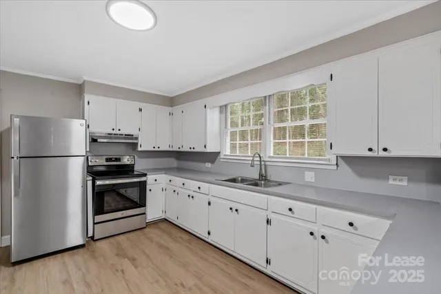 a kitchen with granite countertop white cabinets white appliances and sink