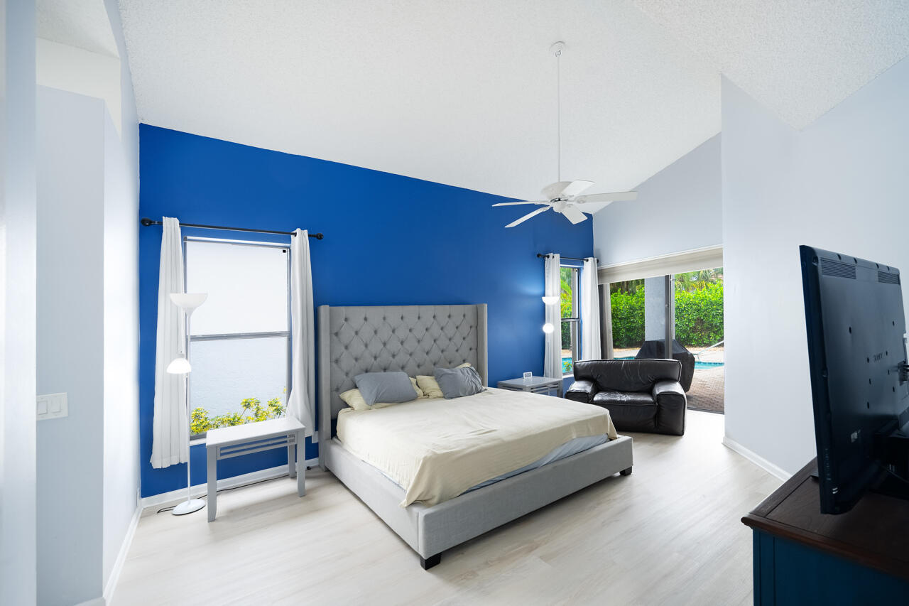 2412 Northwest 63rd Street Boca Raton, FL 33496 - Photo 16 of 53 a bedroom with a bed and a flat screen tv