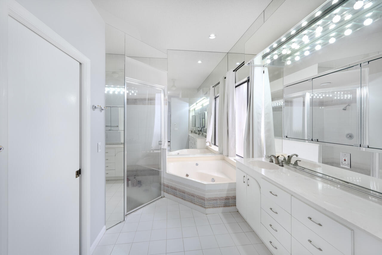 2412 Northwest 63rd Street Boca Raton, FL 33496 - Photo 22 of 53 a bathroom with a double vanity sink mirror double shower and a bathtub