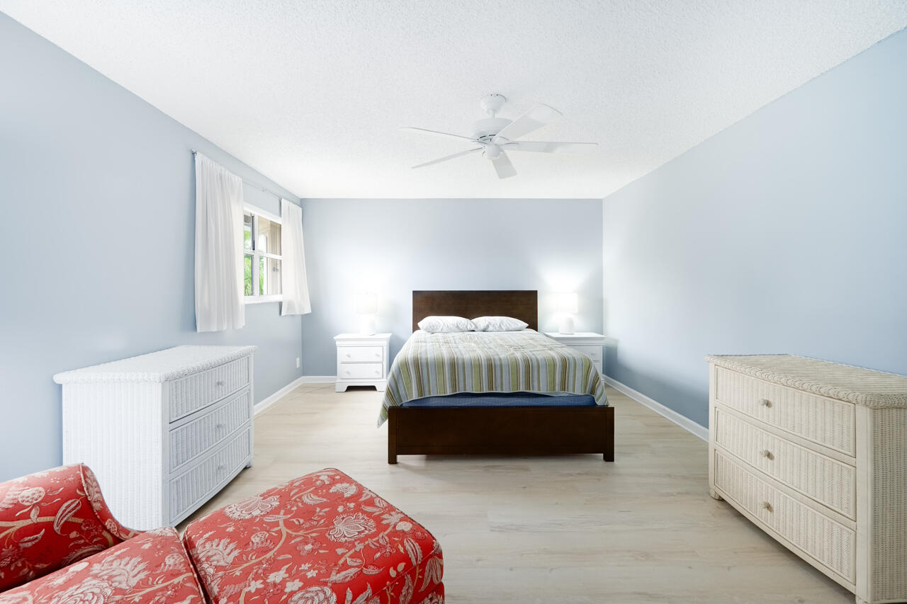 2412 Northwest 63rd Street Boca Raton, FL 33496 - Photo 32 of 53 a bedroom with a bed and a chandelier