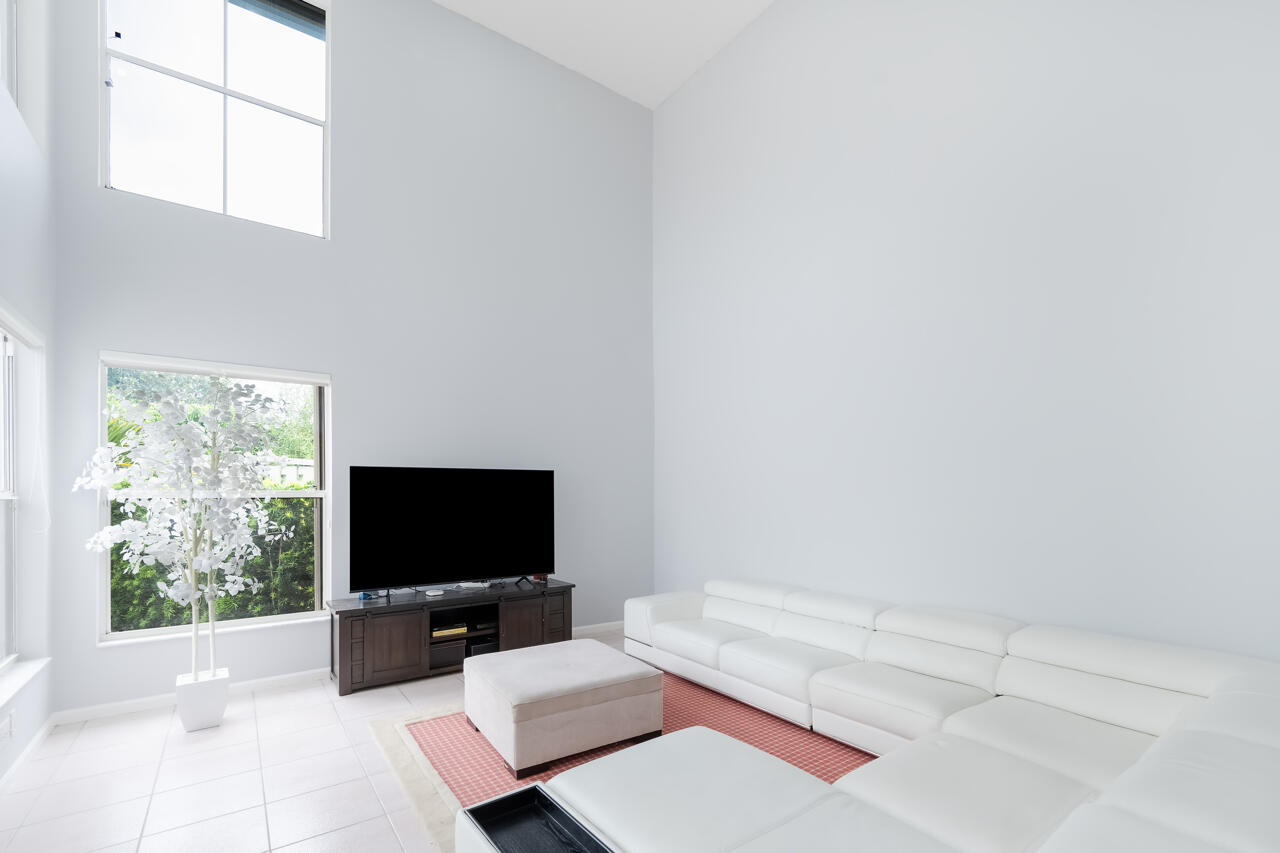 2412 Northwest 63rd Street Boca Raton, FL 33496 - Photo 8 of 53 a living room with furniture and a flat screen tv