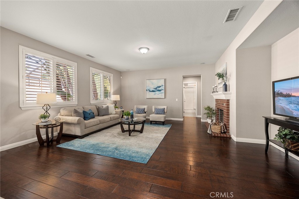 14280 Brant Court Eastvale, CA 92880 - Photo 12 of 47 a living room with fireplace furniture and a wooden floor