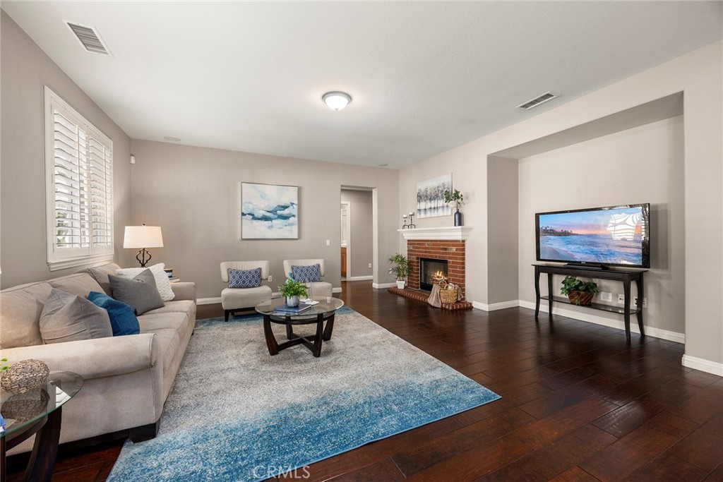 14280 Brant Court Eastvale, CA 92880 - Photo 13 of 47 a living room with fireplace furniture and a wooden floor