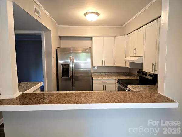 a kitchen with stainless steel appliances granite countertop a sink and a refrigerator