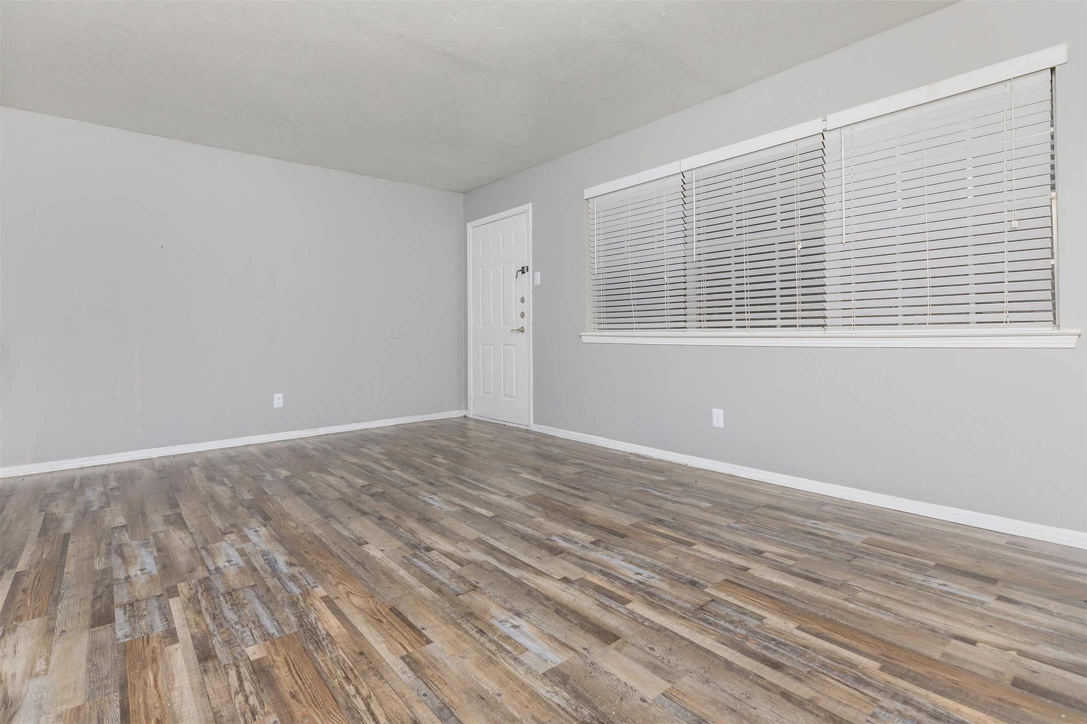 1212 Hampshire Lane, Unit 2111 Richardson, TX 75080 - Photo 12 of 40 a view of an empty room with wooden floor and a window