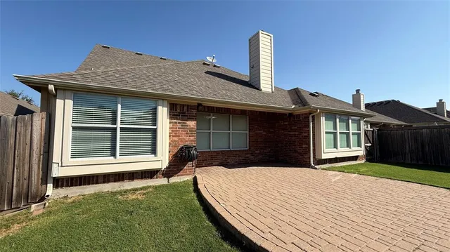 a front view of a house with a yard and wooden fence