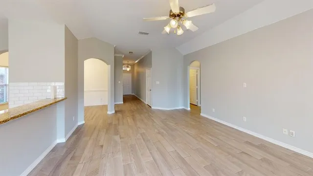 a view of empty room with wooden floor