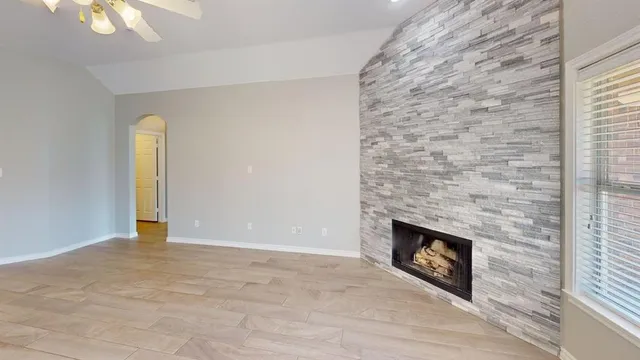 a view of an empty room with a fireplace and a window