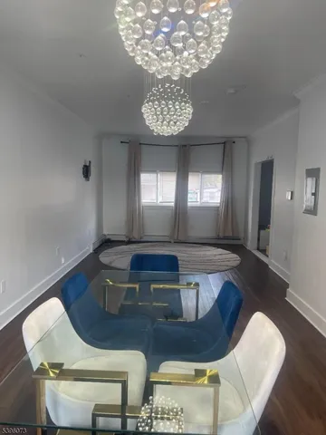 a view of a dining room with furniture a chandelier and wooden floor