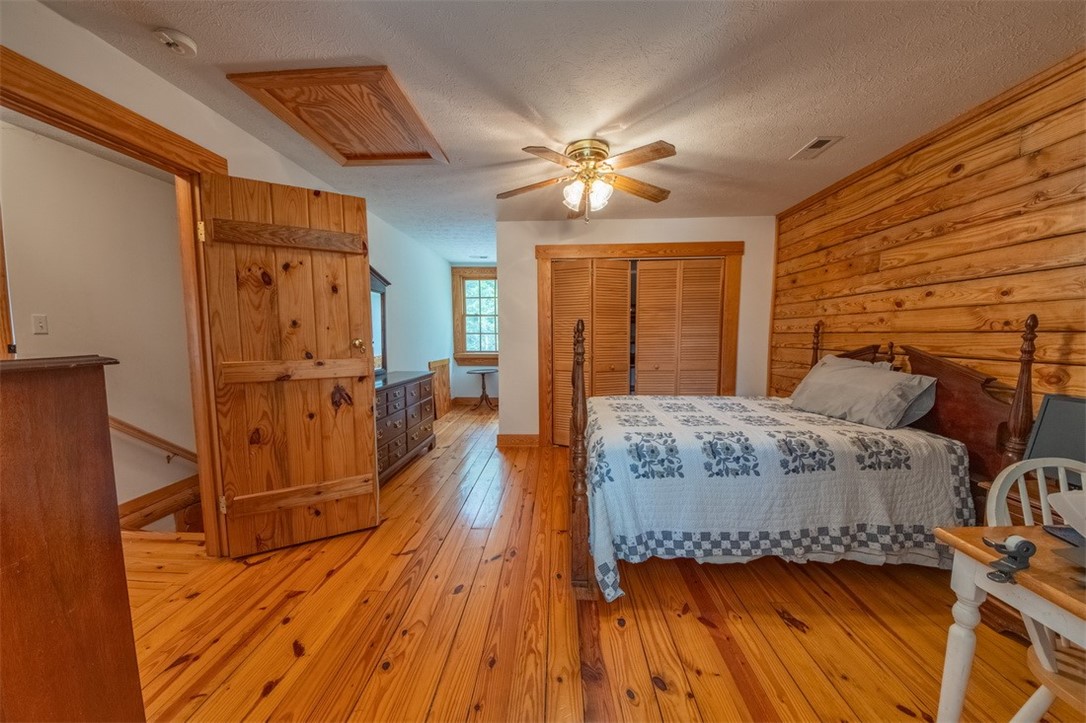 846 Twiggs Ferry Road Hartfield, VA 23071 - Photo 9 of 28 Bedroom with a closet, light wood finished floors, a textured ceiling, and a ceiling fan