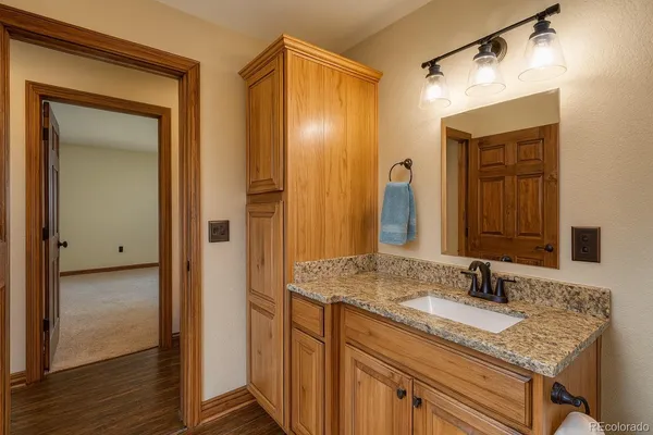 a bathroom with a granite countertop sink and a mirror