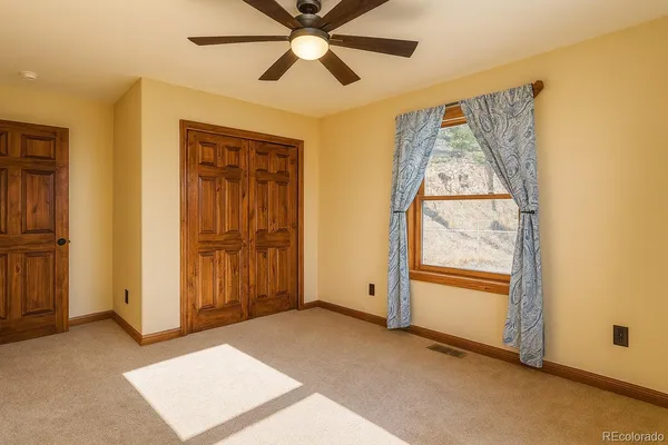 an empty room with windows and fan