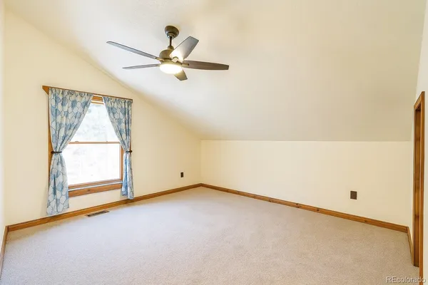 an empty room with a window and a ceiling fan