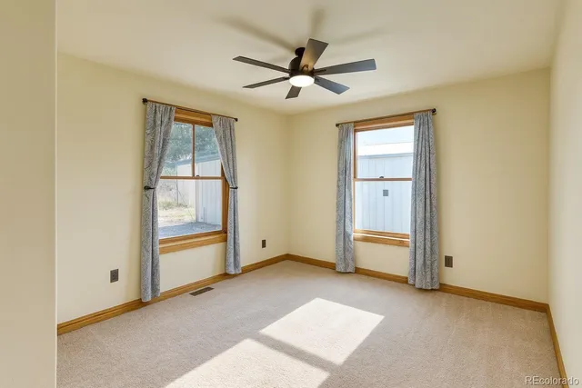an empty room with closet and windows