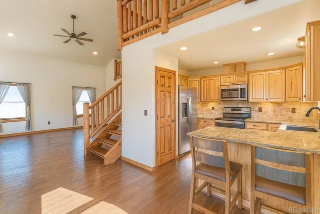 a kitchen with stainless steel appliances granite countertop a refrigerator and a stove top oven