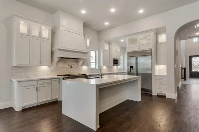 a kitchen with stainless steel appliances granite countertop a stove and white cabinets