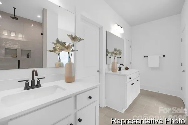a bathroom with a double vanity sink mirror and shower