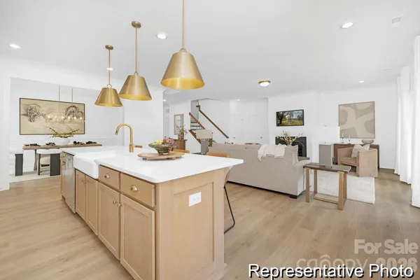 a kitchen with a sink a counter space and a view of living room