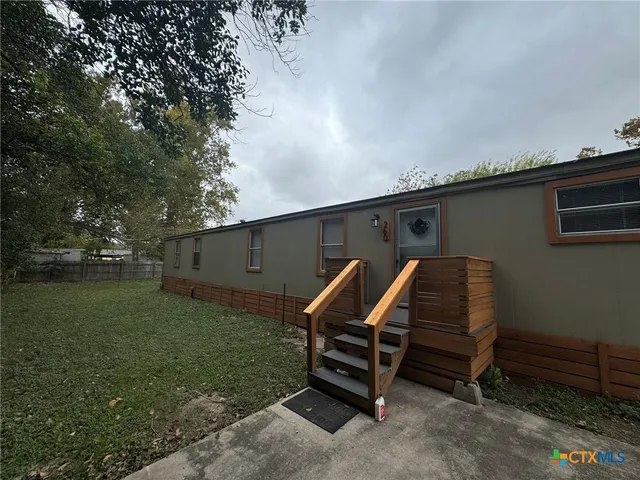 a backyard of a house with barbeque oven table and chairs