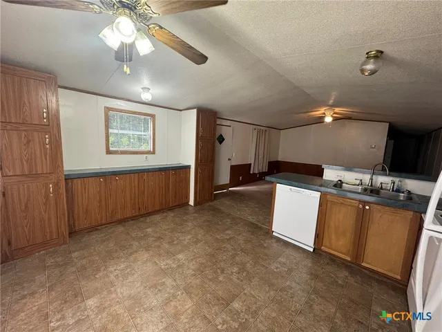 a view of a kitchen with a sink and a ceiling fan