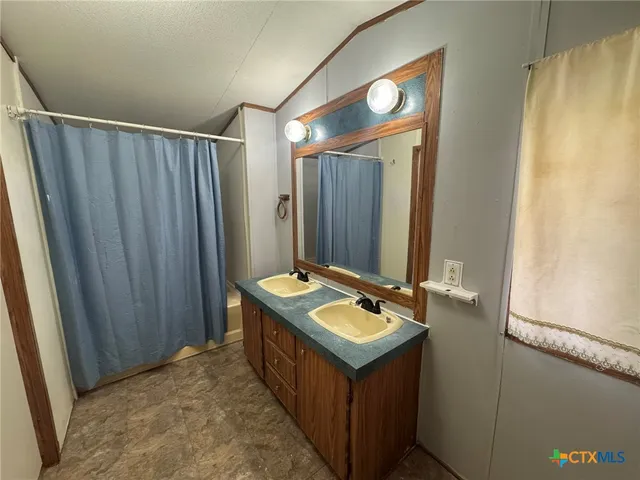 a bathroom with a sink a mirror and a shower