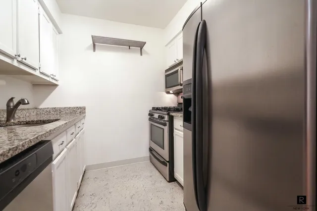 a kitchen with stainless steel appliances granite countertop a stove and a refrigerator