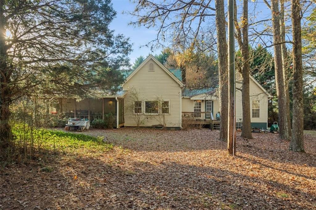 16049 Hopewell Road Alpharetta, GA 30004 - Photo 1 of 30 a view of a house with a yard covered in the forest