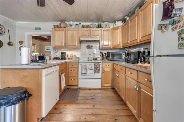 a living room with furniture a flat screen tv and kitchen view
