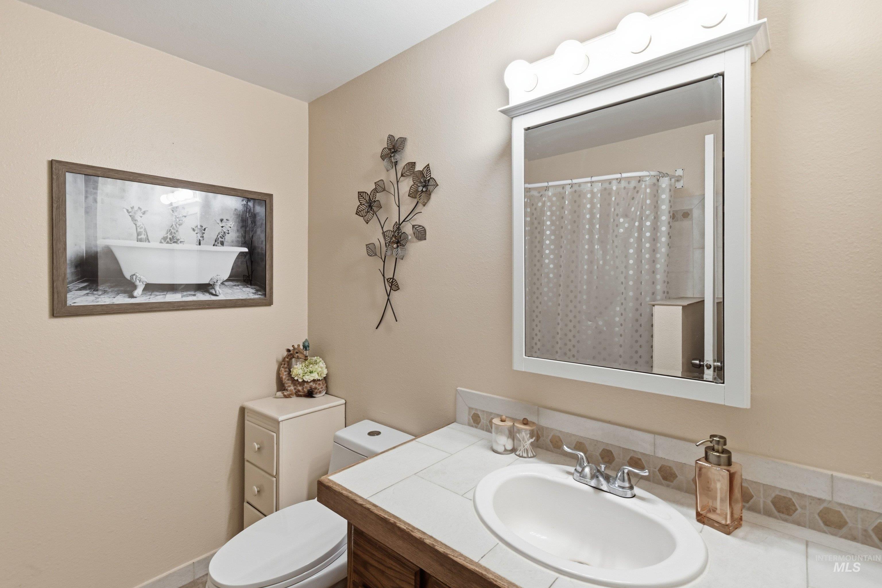 15095 David Street Caldwell, ID 83607 - Photo 19 of 39 Bathroom vanity with an integrated sink, tile countertop, and a decorative tile backsplash