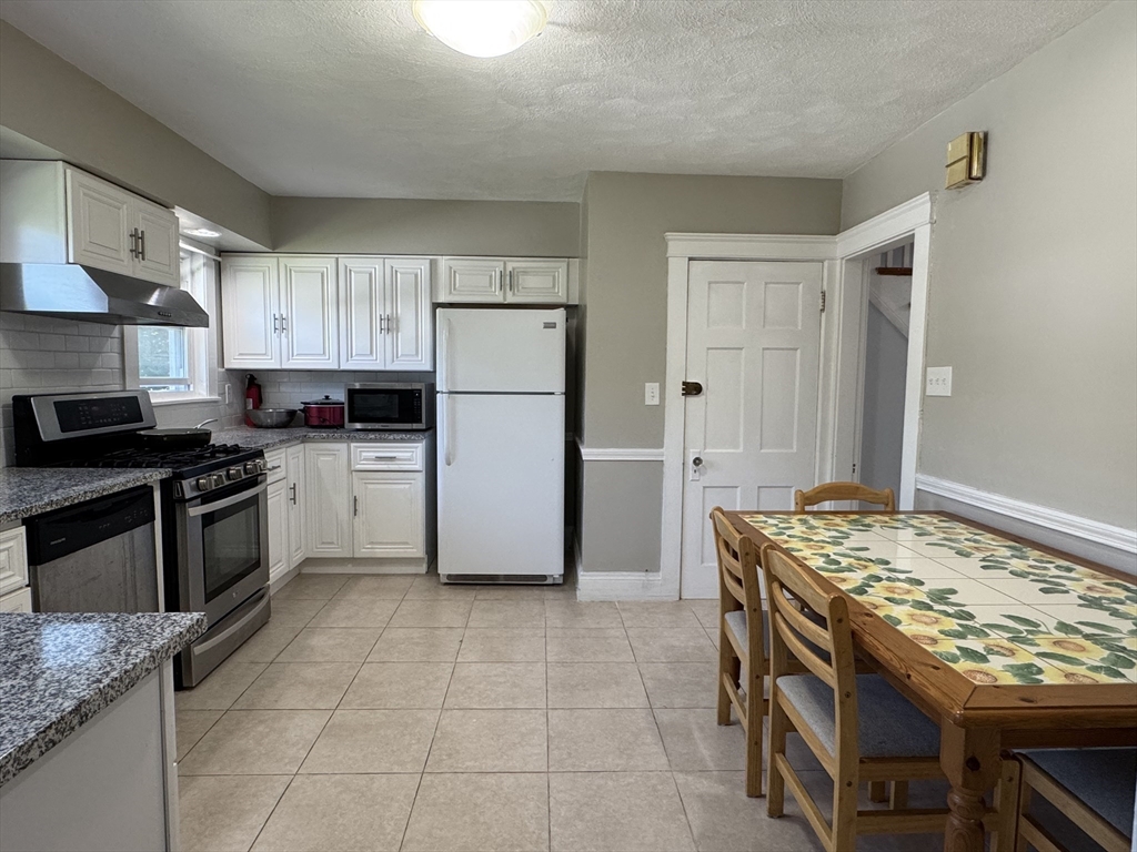 1639 Washington Street Newton, MA 02465 - Photo 5 of 20 a kitchen with granite countertop a sink stove and refrigerator