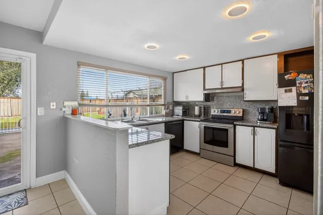 a kitchen with stainless steel appliances a white refrigerator a stove a sink and a microwave