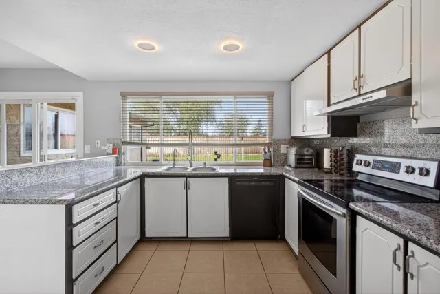 a kitchen with stainless steel appliances granite countertop a stove sink and cabinets