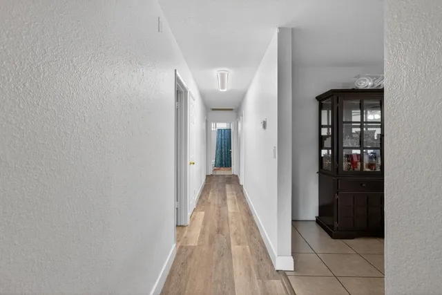 a view of a hallway with wooden floor and entryway