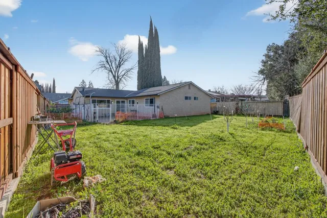 a view of a house with a backyard and a tree