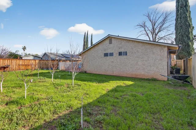 a backyard of a house with table and chairs