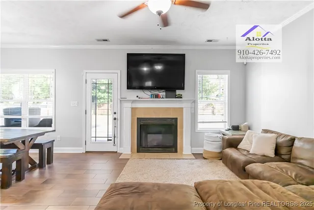 a living room with furniture a flat screen tv and a fireplace