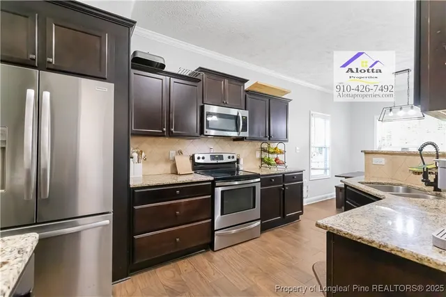 a kitchen with granite countertop stainless steel appliances and wooden cabinets