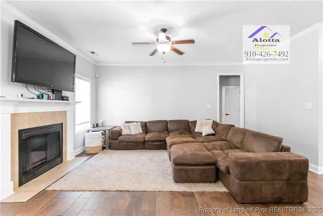 a living room with furniture a flat screen tv and a fireplace