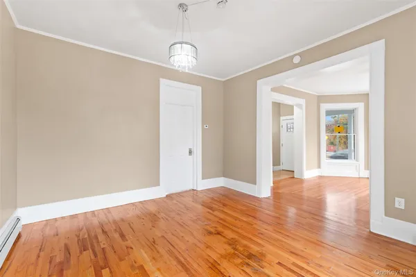 a view of an empty room with wooden floor