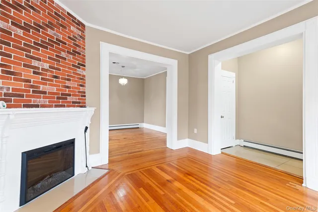 a view of a livingroom with wooden floor and a fireplace