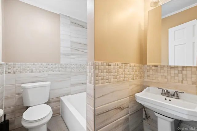 a bathroom with a sink a toilet and mirror