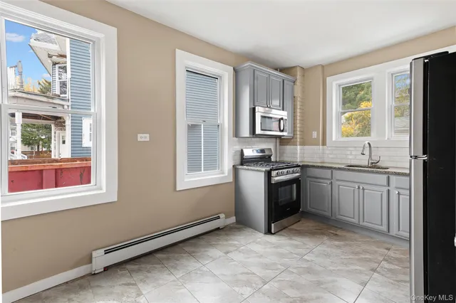 a kitchen with stainless steel appliances granite countertop a stove a sink and a refrigerator